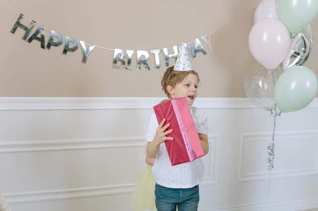 Sinnvolle Geschenke für Kinder - Junge mit Geschenk zum Geburtstag