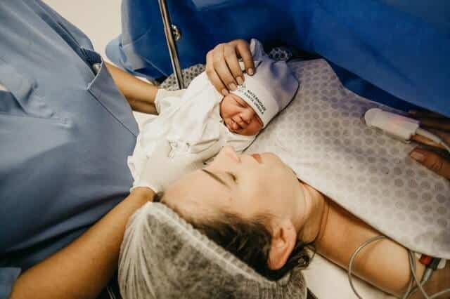 Kaiserschnitt - Neugeborenes mit Mutter im Kreißsaal
