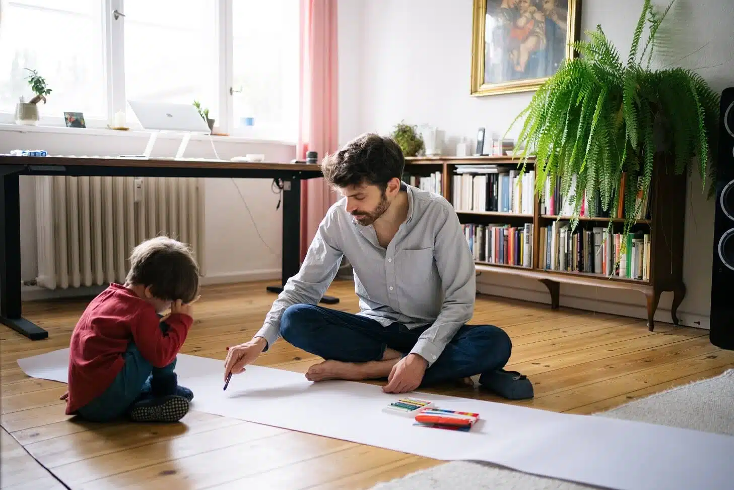 Pflegekind aufnehmen - Pflegevater Tobias Wilhelm mit seinem Pflegekind in Wohnzimmer