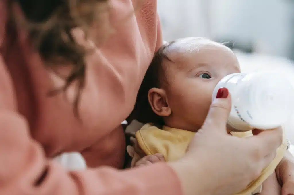 mutter-gibt-saeugling-flasche-mit-milch