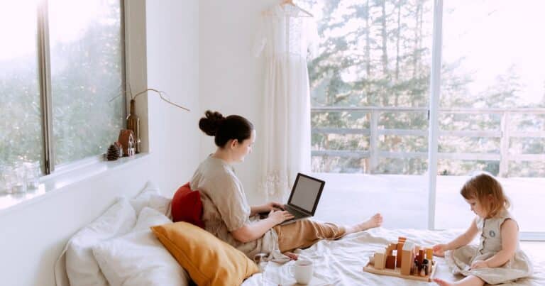 rabenmutter-header-grafik_mutter-mit-laptop-auf-bett-mit-tochter