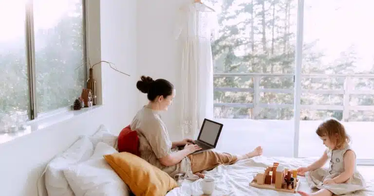 rabenmutter-header-grafik_mutter-mit-laptop-auf-bett-mit-tochter