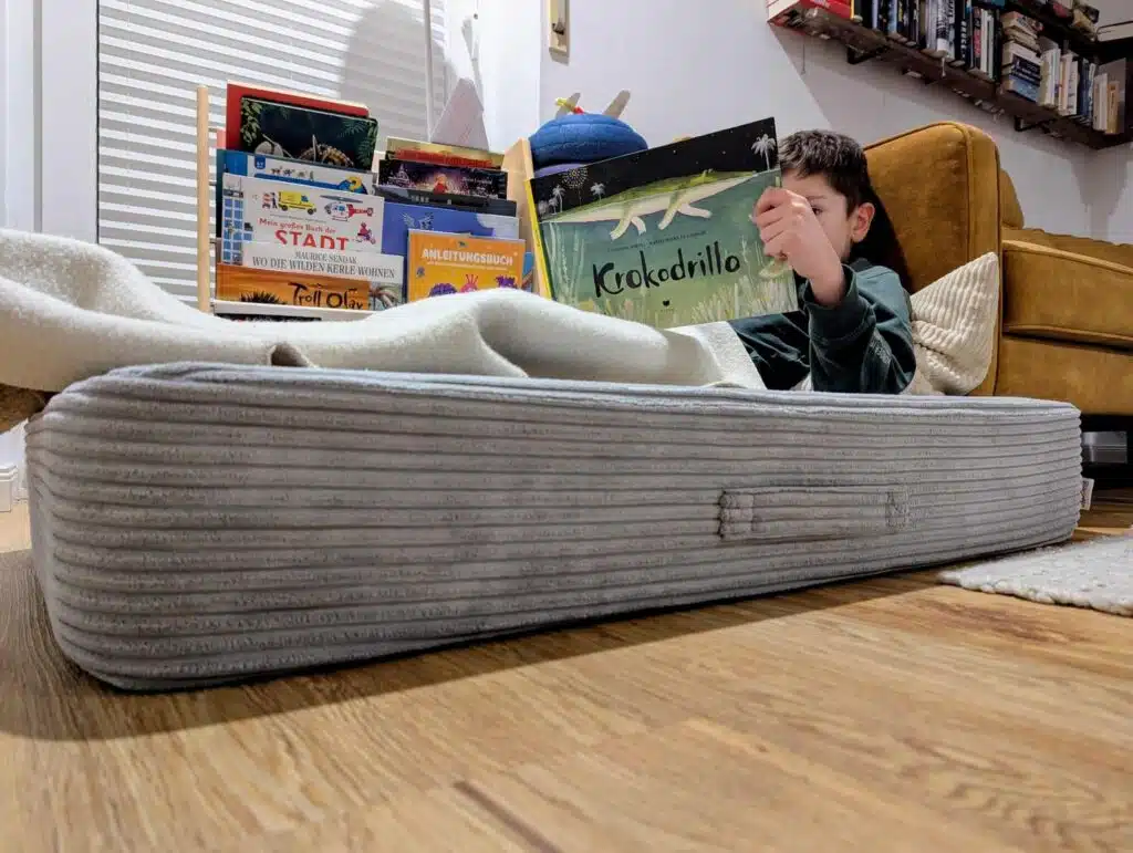 junge-auf-linodino-huepfkissen-liest-buch